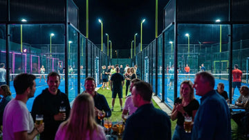 A crowd of people socialising next to a padel court