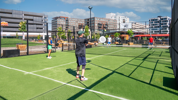 People playing padel on a green open court