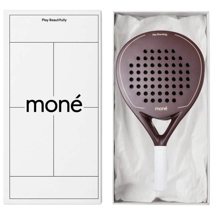 Luxury unboxing of the designer Moné Padel Cocoa racket inside a premium white presentation box.