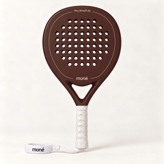 Cocoa brown padel racket by moné, front view: teardrop head, Play Beautifully lettering, white grip and wrist strap
