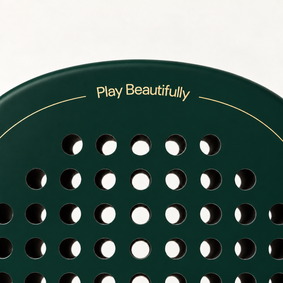 Play Beautifully printed in gold at the top of the Forest dark green padel racket, above its drilled hole pattern
