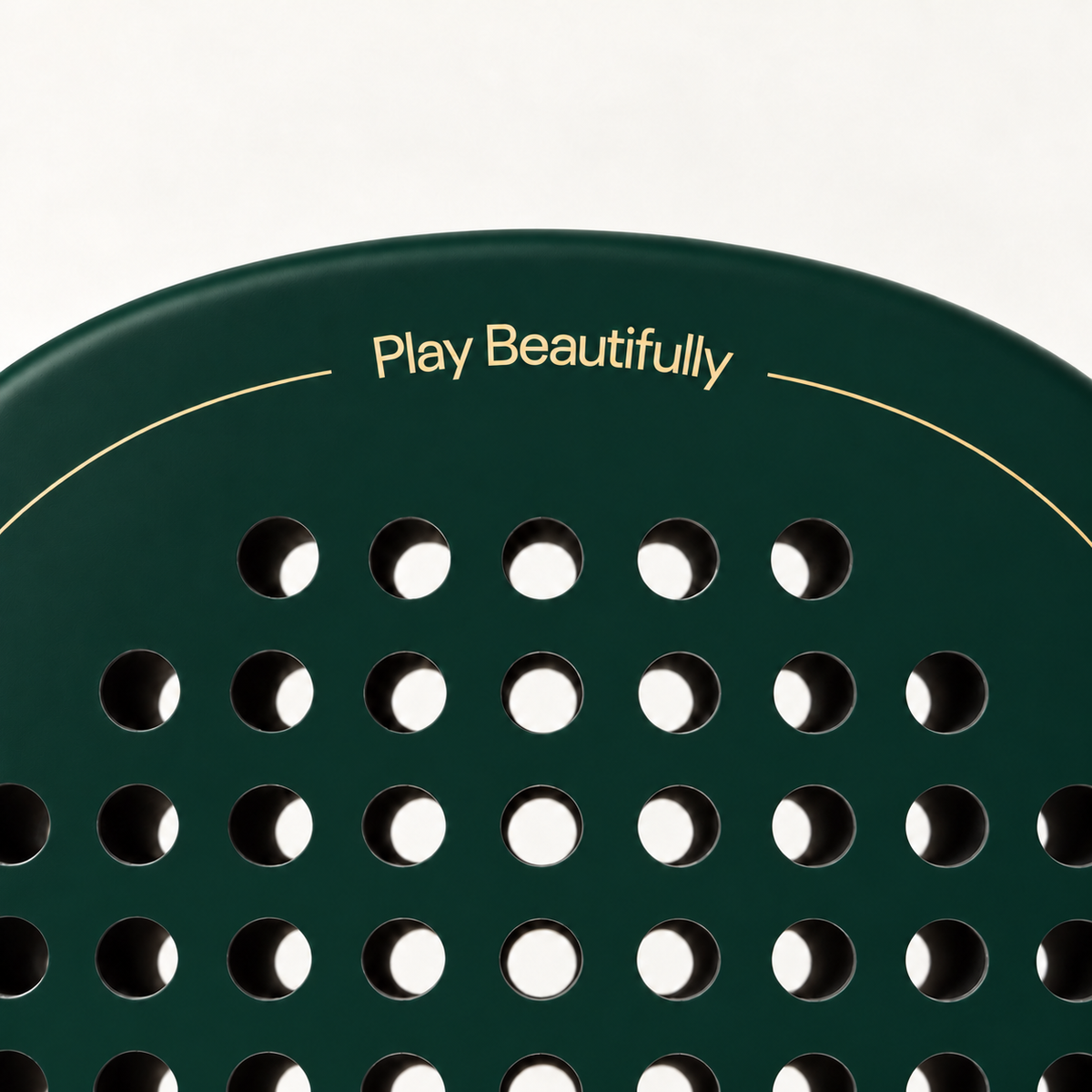 Play Beautifully printed in gold at the top of the Forest dark green padel racket, above its drilled hole pattern