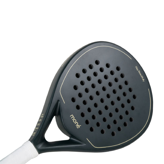 Detailed view of the Moné Padel Forest racket surface showing the teardrop hole pattern and matte finish.
