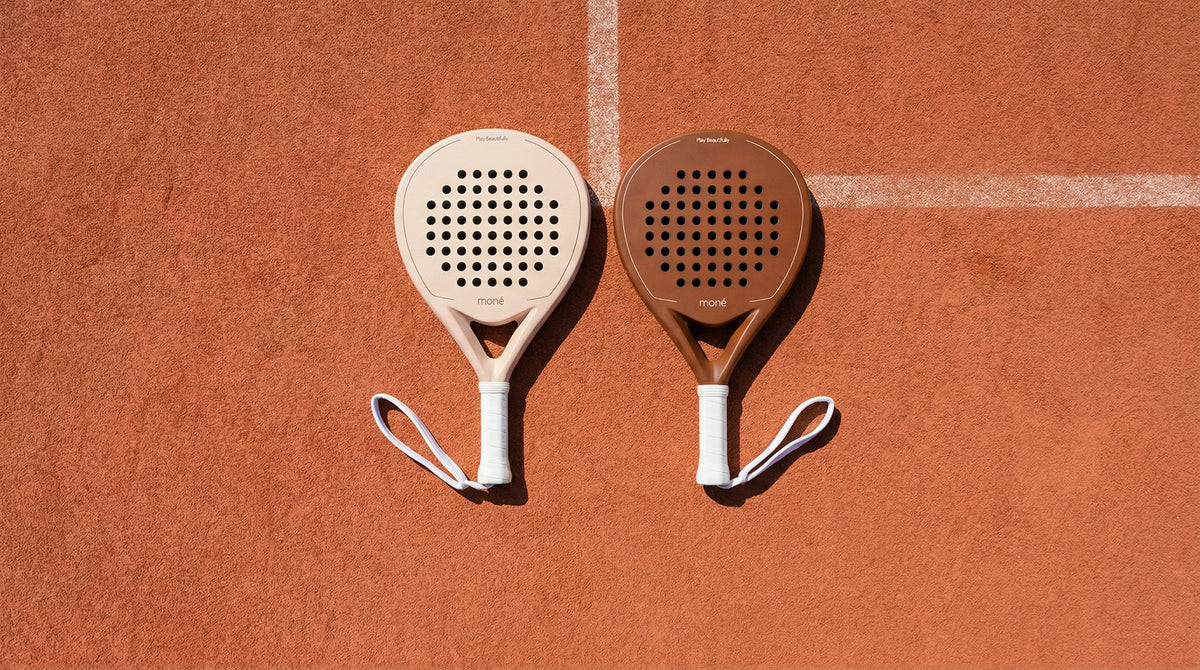 Premium Moné padel rackets duo on a terracotta clay court – cream and cocoa | Moné Padel 