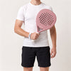 Man in a white T-shirt and black shorts holding the pink Himalaya Hybrid padel racket in front of his chest
