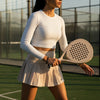 Female player in beige padel apparel holding the lightweight Moné Padel Sahara racket on court.
