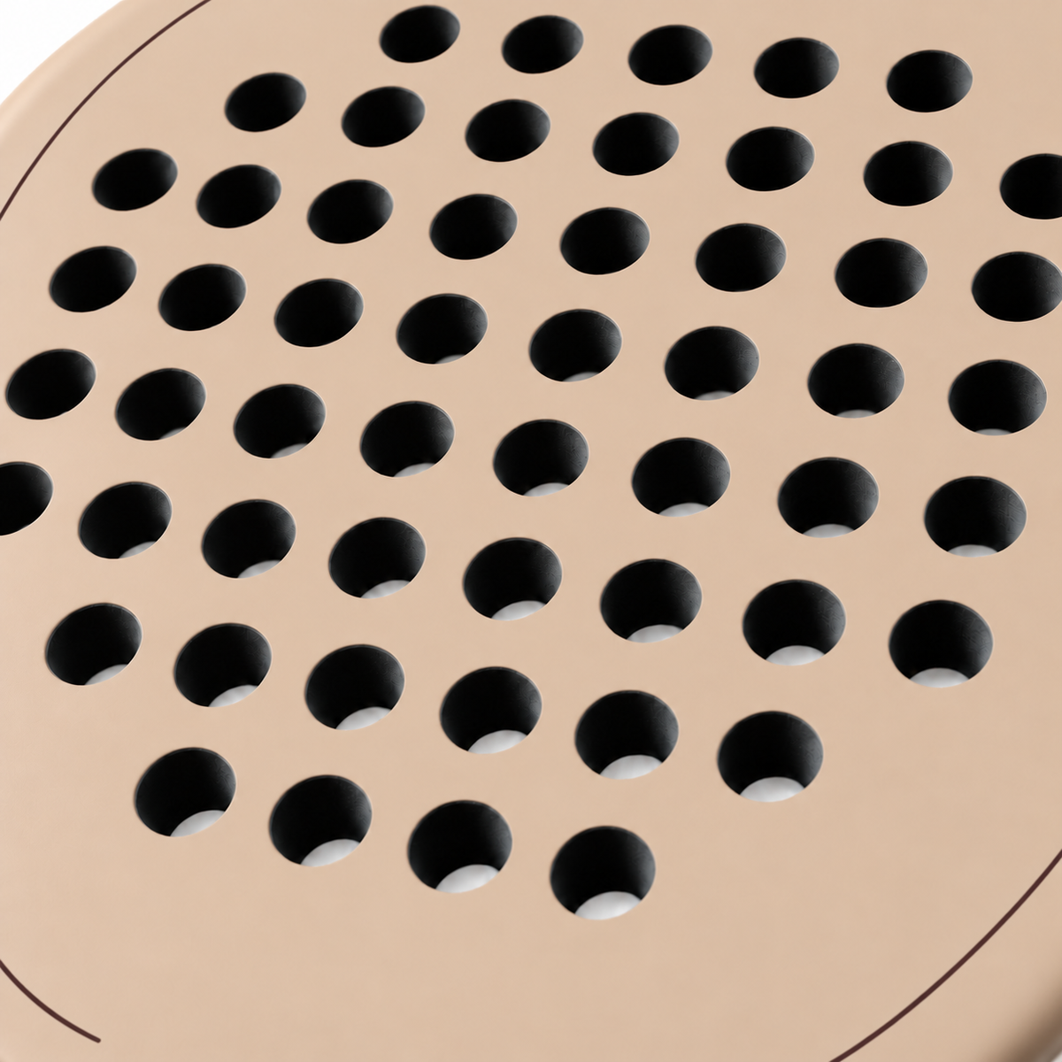 Macro of the Sahara beige padel racket face, showing its matte finish, drilled hole pattern and thin cocoa brown outline
