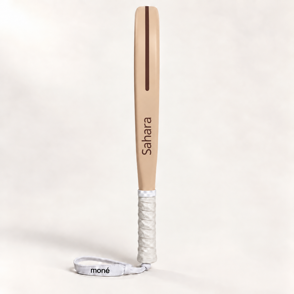Sahara beige padel racket in side profile, with Sahara printed in cocoa brown along the frame, a white grip and wrist strap