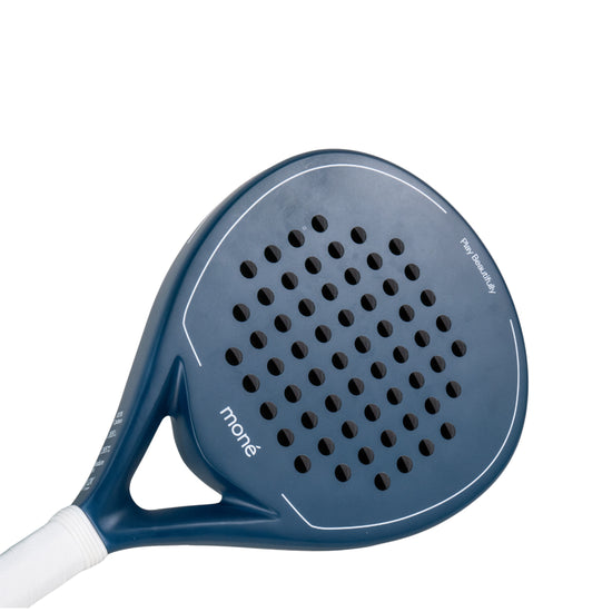 Detailed surface view of the Moné Padel premium racket showing its teardrop hole pattern and matte finish.