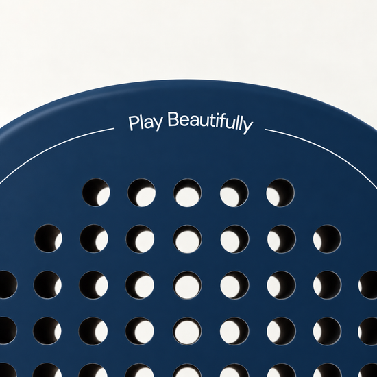 Play Beautifully printed in white at the top of the Sailor blue padel racket, above its drilled hole pattern