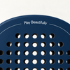 Play Beautifully printed in white at the top of the Sailor blue padel racket, above its drilled hole pattern