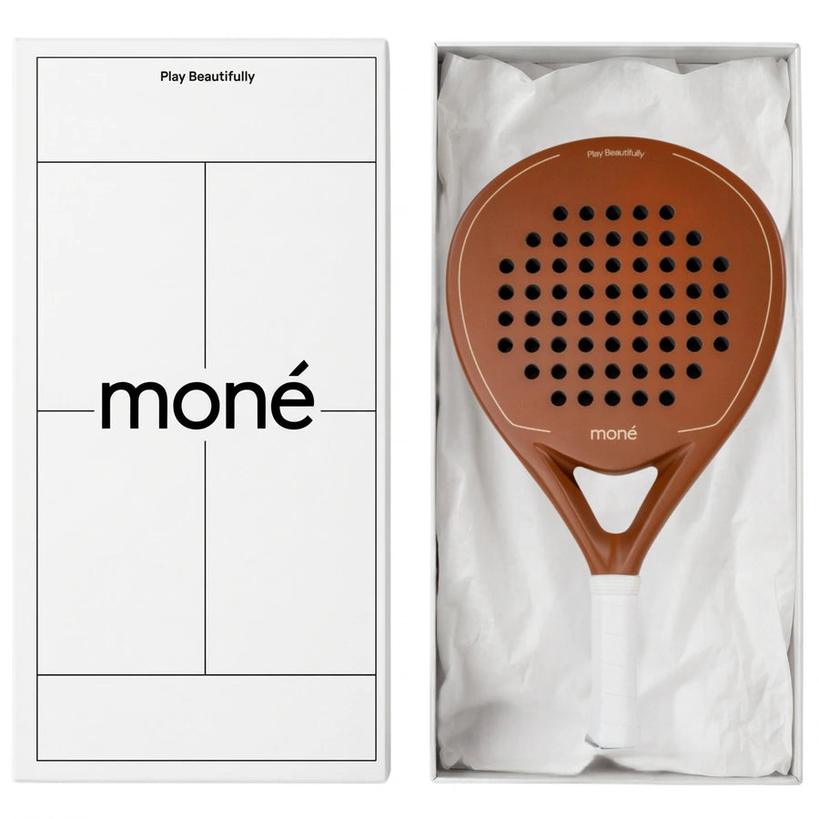Luxury unboxing of the designer Moné Padel Sienna racket inside a premium white presentation box.