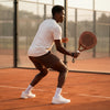 Male player on a clay court preparing for a shot with the high-performance 12K carbon Moné Padel Sienna racket.