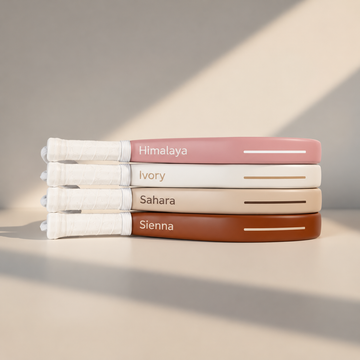 Four moné Hybrid padel rackets stacked: Himalaya pink, Ivory off-white, Sahara beige and Sienna light brown