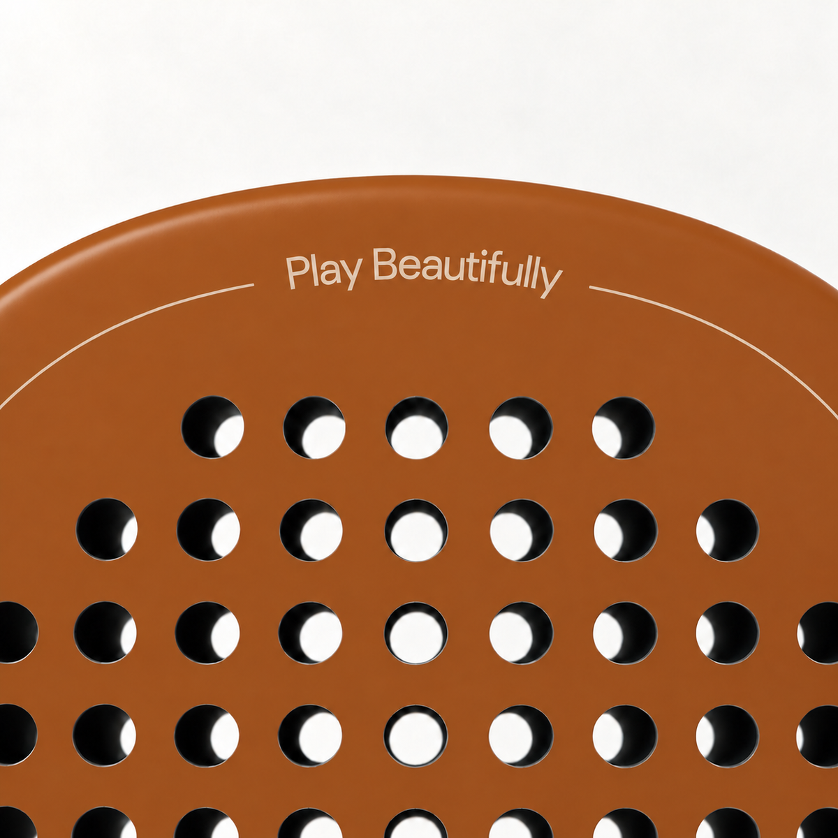 Play Beautifully printed in cream at the top of the Sienna light brown padel racket, above its drilled hole pattern
