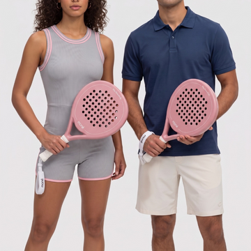Woman and man each hold the pink Himalaya Hybrid padel racket by moné, with white moné wrist straps