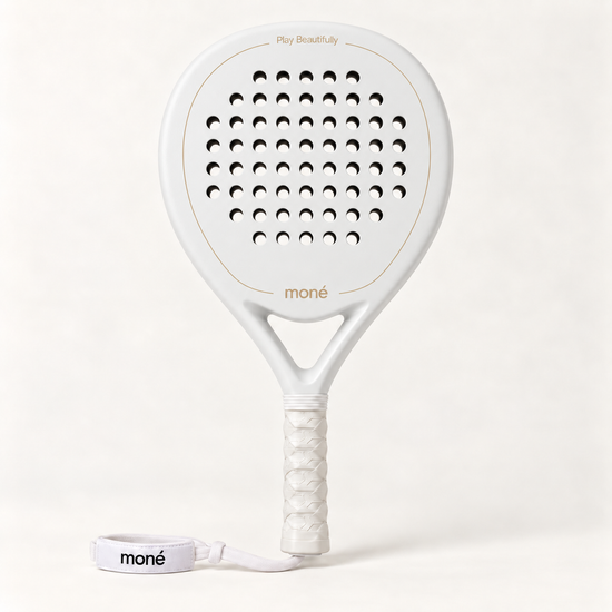 Front view of the off-white Ivory Hybrid padel racket with a gold moné logo, white grip and matching wrist strap
