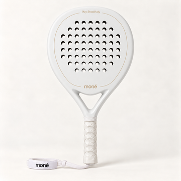 Front view of the off-white Ivory Hybrid padel racket with a gold moné logo, white grip and matching wrist strap