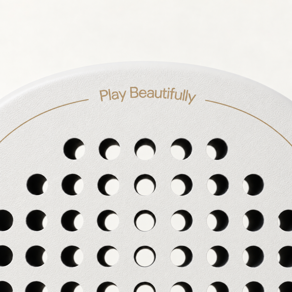 Play Beautifully in gold lettering across the top of the off-white Ivory Hybrid padel racket face and holes