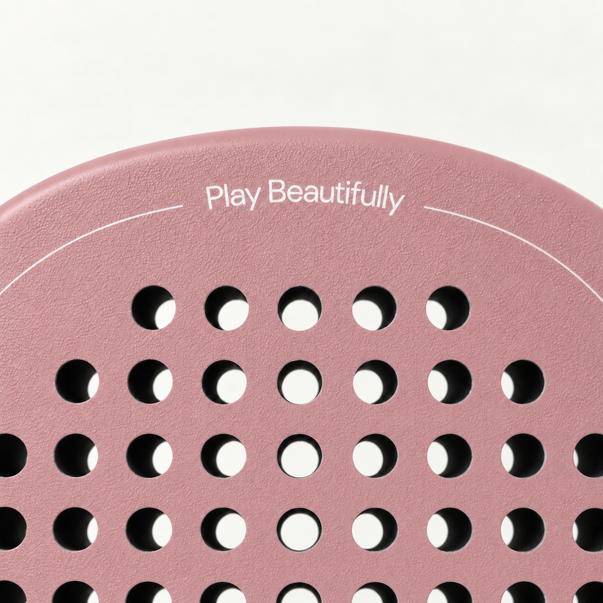 Top of the pink Himalaya Hybrid padel racket face, with Play Beautifully printed in white above the holes