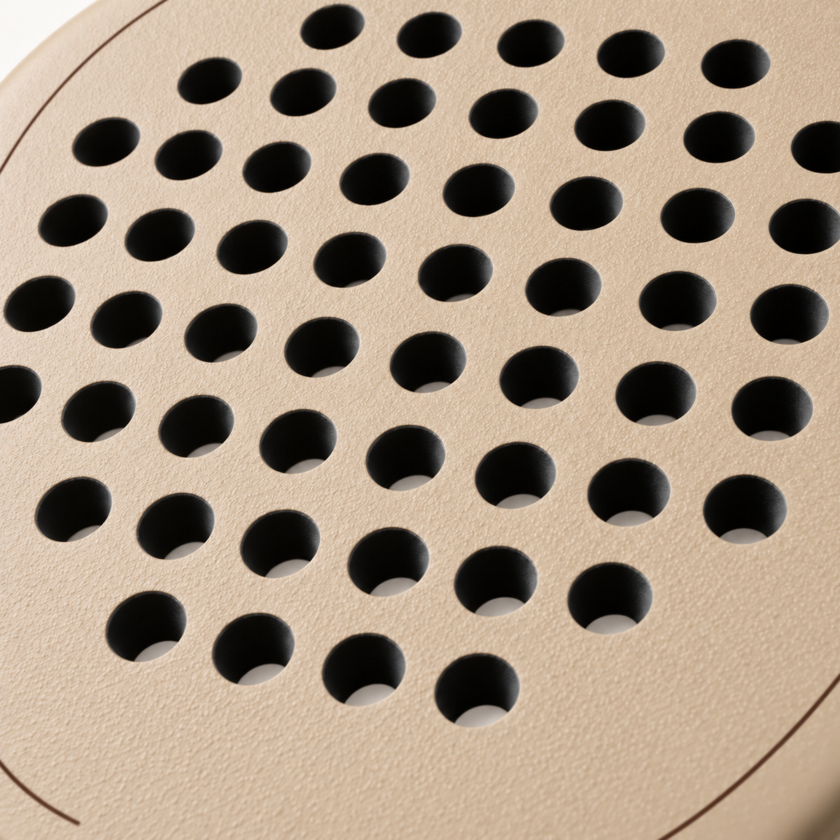 Macro view of the rough, textured beige face of the Sahara Hybrid padel racket, a finish made to help generate spin