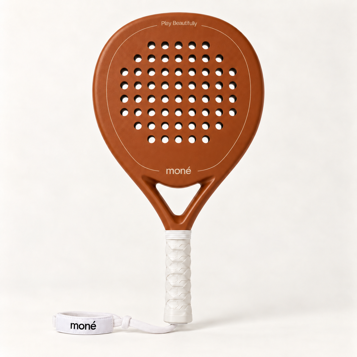 Sienna Hybrid padel racket in light brown by moné, front view with Play Beautifully lettering, a white grip and wrist strap
