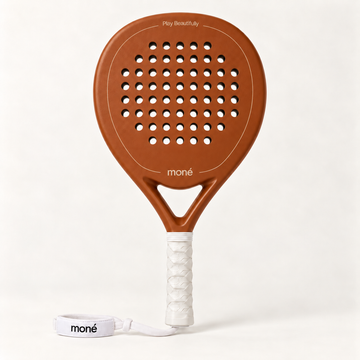 Sienna Hybrid padel racket in light brown by moné, front view with Play Beautifully lettering, a white grip and wrist strap