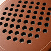 Rough, grainy light brown surface of the Sienna Hybrid padel racket in macro, textured around the holes to help spin